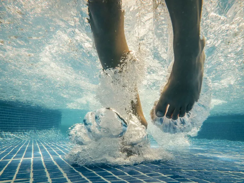 Chorro de burbujas bajo el agua de una piscina en funcionamiento