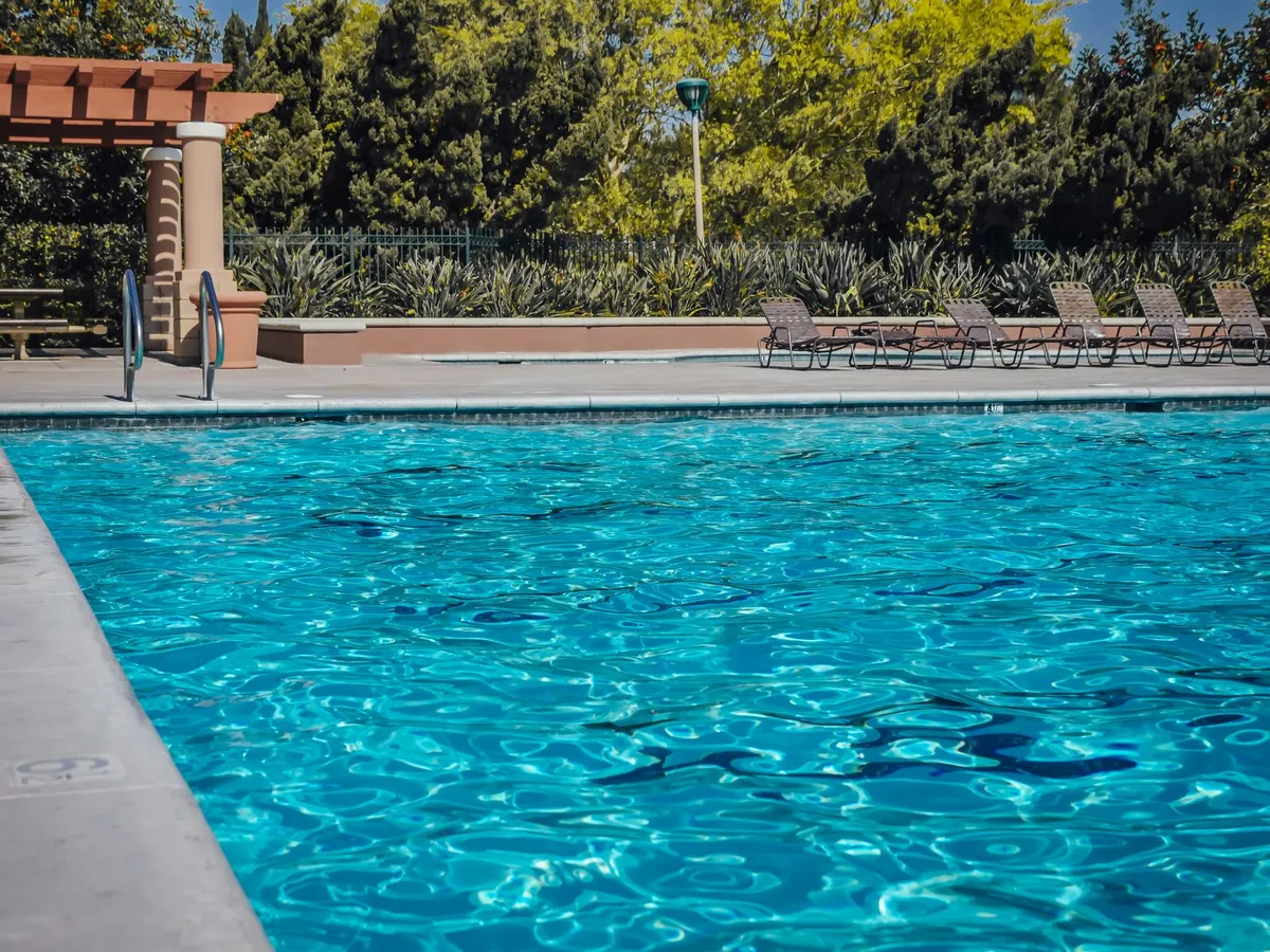 Piscina moderna con tarima de adoquines en el exterior de una casa