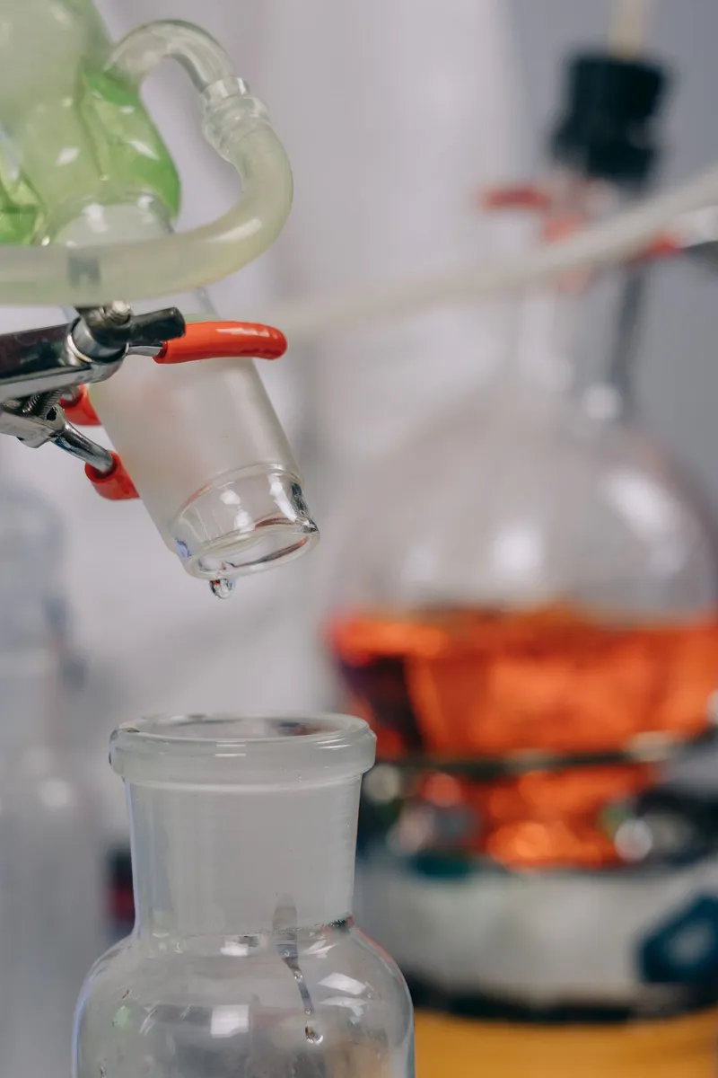 Material de vidrio de laboratorio goteando una muestra líquida para su análisis